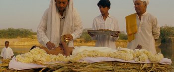 Movie still from “The Darjeeling Limited” (2007), directed by Wes Anderson – A man is getting his legs waxed by another man; Medium shot, High angle
