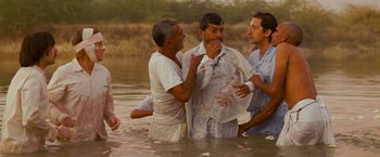 Movie still from “The Darjeeling Limited” (2007), directed by Wes Anderson – A group of men standing in a body of water; Medium shot, High angle