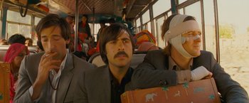 Movie still from “The Darjeeling Limited” (2007), directed by Wes Anderson – A man sitting on top of a bus with a beard; Medium shot, Low angle