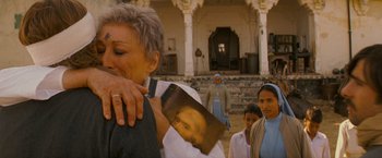 Movie still from “The Darjeeling Limited” (2007), directed by Wes Anderson – An older woman holding a picture of jesus; Medium shot, Over the shoulder angle