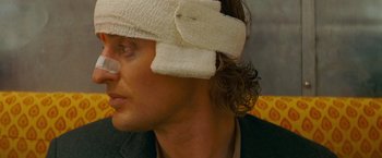 Movie still from “The Darjeeling Limited” (2007), directed by Wes Anderson – A man with bandages on his head and a bandage on his face; Close Up shot, Over the shoulder angle