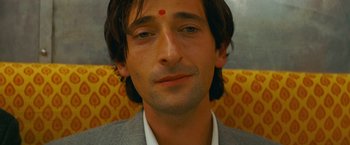 Movie still from “The Darjeeling Limited” (2007), directed by Wes Anderson – A person with a red dot on his forehead; Close Up shot, High angle