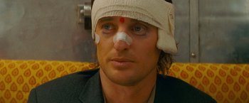 Movie still from “The Darjeeling Limited” (2007), directed by Wes Anderson – A person with bandage on his head; Close Up shot, Over the shoulder angle