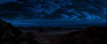Movie still from “The Dark Crystal” (1982), directed by Frank Oz – A painting of a dark night sky with clouds; Extreme Wide shot, Low angle