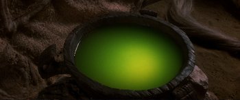 Movie still from “The Dark Crystal” (1982), directed by Frank Oz – A bowl of green liquid sitting on top of a table; Extreme Close Up shot, Overhead angle