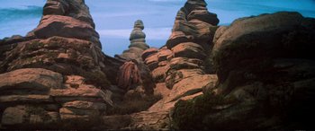 Movie still from “The Dark Crystal” (1982), directed by Frank Oz – A large rock formation in the middle of the desert; Extreme Wide shot, Low angle