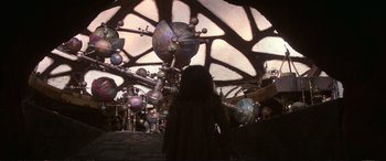 Movie still from “The Dark Crystal” (1982), directed by Frank Oz – A woman standing in front of a ceiling full of planets; Wide shot, Low angle