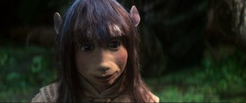 Movie still from “The Dark Crystal” (1982), directed by Frank Oz – A woman with a long brown hair wearing a brown and black costume; Close Up shot, High angle