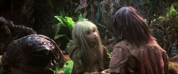 Movie still from “The Dark Crystal” (1982), directed by Frank Oz – Two children dressed like elves in a forest; Medium shot, Over the shoulder angle