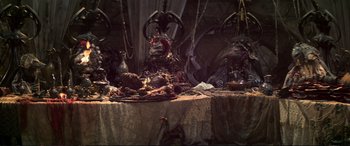 Movie still from “The Dark Crystal” (1982), directed by Frank Oz – A table covered with a lot of stuff on top of it; Wide shot, High angle