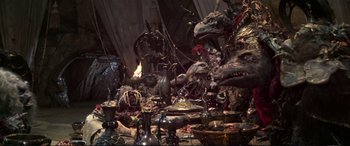 Movie still from “The Dark Crystal” (1982), directed by Frank Oz – A lot of strange stuff on the table; Wide shot, High angle