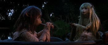 Movie still from “The Dark Crystal” (1982), directed by Frank Oz – A woman sitting in front of a body of water; Medium shot, High angle