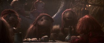Movie still from “The Dark Crystal” (1982), directed by Frank Oz – A group of stuffed animals sitting next to each other on top of a table; Medium shot, Low angle