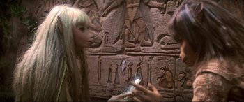 Movie still from “The Dark Crystal” (1982), directed by Frank Oz – A woman holding a cell phone up to her face; Close Up shot, High angle