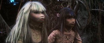Movie still from “The Dark Crystal” (1982), directed by Frank Oz – A couple of people that are standing in the grass; Close Up shot, High angle
