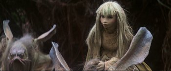 Movie still from “The Dark Crystal” (1982), directed by Frank Oz – A doll sitting on top of a tree stump; Close Up shot, High angle