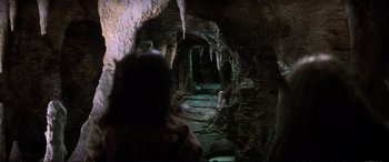 Movie still from “The Dark Crystal” (1982), directed by Frank Oz – A person is standing in a cave looking at the ground; Wide shot, High angle