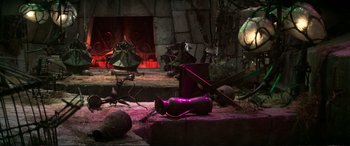 Movie still from “The Dark Crystal” (1982), directed by Frank Oz – A fireplace with a purple fire hydrant sitting next to it; Wide shot, High angle