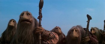 Movie still from “The Dark Crystal” (1982), directed by Frank Oz – A person holding a stick; Medium shot, Low angle
