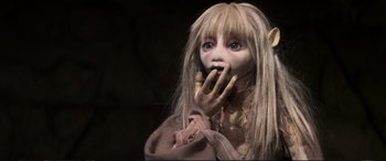 Movie still from “The Dark Crystal” (1982), directed by Frank Oz – A doll with long blonde hair and blue eyes; Close Up shot, High angle