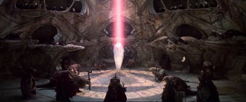 Movie still from “The Dark Crystal” (1982), directed by Frank Oz – A light beam is coming out of the center of a room; Extreme Wide shot, High angle