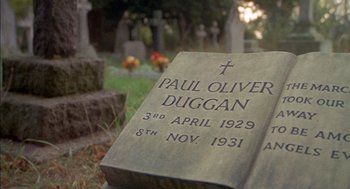 Movie still from “The Day of the Jackal” (1973), directed by Fred Zinnemann – A grave stone with the name paul oliver duggan engraved on it; Extreme Close Up shot, High angle