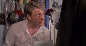 Movie still from “The Day of the Jackal” (1973), directed by Fred Zinnemann – A person with a bruise on his face; Close Up shot, Over the shoulder angle