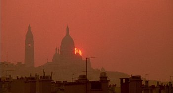Movie still from “The Day of the Jackal” (1973), directed by Fred Zinnemann – The sun is setting behind a large building; Extreme Wide shot, Low angle