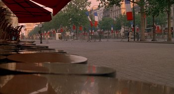 Movie still from “The Day of the Jackal” (1973), directed by Fred Zinnemann – A view of a street with a lot of flags on the ground; Extreme Wide shot, High angle