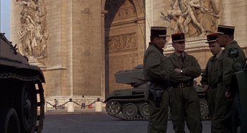 Movie still from “The Day of the Jackal” (1973), directed by Fred Zinnemann – Two men in military fatigues standing next to a tank; Wide shot, Low angle