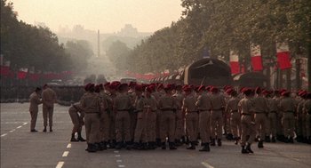 Movie still from “The Day of the Jackal” (1973), directed by Fred Zinnemann – A group of men in uniform standing in the middle of the street; Extreme Wide shot, High angle