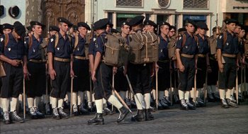 Movie still from “The Day of the Jackal” (1973), directed by Fred Zinnemann – A group of men standing next to each other on a street; Wide shot, High angle