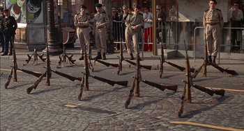 Movie still from “The Day of the Jackal” (1973), directed by Fred Zinnemann – A group of men standing next to each other with guns; Wide shot, High angle