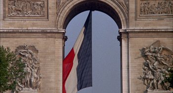 Movie still from “The Day of the Jackal” (1973), directed by Fred Zinnemann – A french flag is hanging in the arch of the arc de triomphe in paris; Extreme Wide shot, Low angle