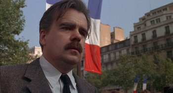 Movie still from “The Day of the Jackal” (1973), directed by Fred Zinnemann – A person wearing a suit and tie; Close Up shot, Low angle