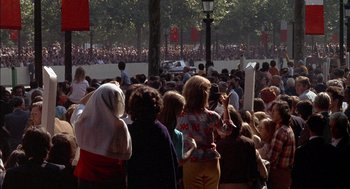 Movie still from “The Day of the Jackal” (1973), directed by Fred Zinnemann – A large crowd of people gathered in a parking lot; Extreme Wide shot, High angle