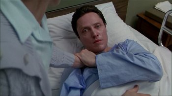 Movie still from “The Dead Zone” (1983), directed by David Cronenberg – A man laying in a hospital bed with a hand on his chest; Close Up shot, High angle