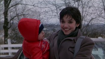 Movie still from “The Dead Zone” (1983), directed by David Cronenberg – A woman and a child smiling for the camera; Close Up shot, Low angle