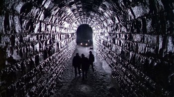 Movie still from “The Dead Zone” (1983), directed by David Cronenberg – A group of people walking through a tunnel; Wide shot, High angle