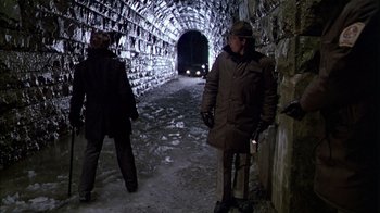 Movie still from “The Dead Zone” (1983), directed by David Cronenberg – Two people in a tunnel with a car in the background; Wide shot, Over the shoulder angle