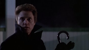 Movie still from “The Dead Zone” (1983), directed by David Cronenberg – A man in a black jacket holding an umbrella; Close Up shot, Low angle