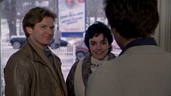 Movie still from “The Dead Zone” (1983), directed by David Cronenberg – A group of people standing next to each other on the street; Medium shot, Over the shoulder angle