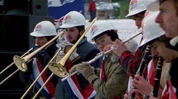 Movie still from “The Dead Zone” (1983), directed by David Cronenberg – A group of men playing flutes in the snow; Medium shot, Low angle