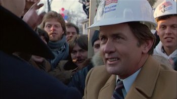 Movie still from “The Dead Zone” (1983), directed by David Cronenberg – A man wearing a hard hat in a crowd; Close Up shot, Low angle