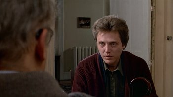 Movie still from “The Dead Zone” (1983), directed by David Cronenberg – A man sitting in front of another man in front of a mirror; Close Up shot, Over the shoulder angle