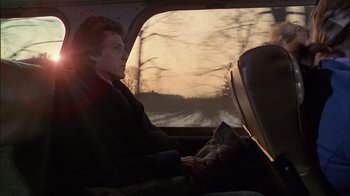 Movie still from “The Dead Zone” (1983), directed by David Cronenberg – A man sitting in the back seat of a car; Medium shot, Low angle