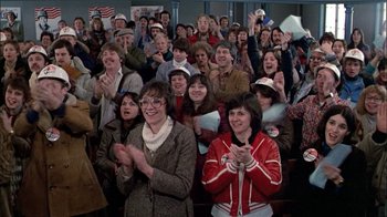 Movie still from “The Dead Zone” (1983), directed by David Cronenberg – A group of people clapping in a room; Medium shot, High angle
