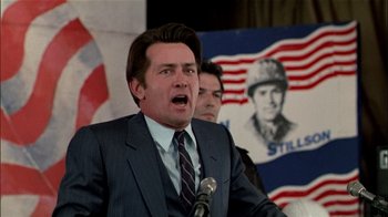 Movie still from “The Dead Zone” (1983), directed by David Cronenberg – A man in a suit and tie speaking into a microphone; Close Up shot, Low angle