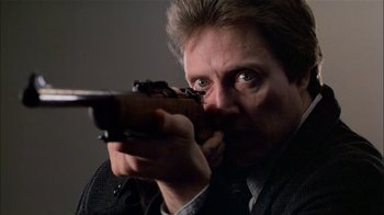 Movie still from “The Dead Zone” (1983), directed by David Cronenberg – A person holding a gun; Close Up shot, Low angle
