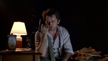 Movie still from “The Dead Zone” (1983), directed by David Cronenberg – A man sitting on a chair holding a cell phone to his ear; Close Up shot, Low angle